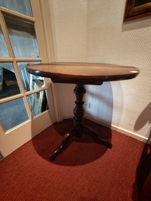 une petite table avec un plateau en bois posée sur un tapis rouge