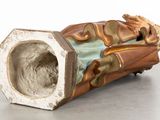 a ceramic sculpture of a man laying on the ground