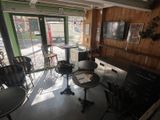 a room with tables and chairs in it and a television on the wall
