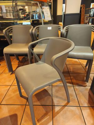 Plusieurs chaises sont alignées dans un restaurant, en attendant les clients.