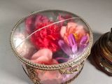 a glass box with flowers inside of it on a table