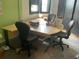 a desk with two chairs and a table with a book on it