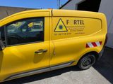 the yellow van is parked in front of a building with a warning sign on it