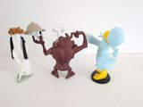 three figurines of different characters on a white surface