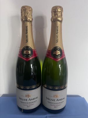 Deux bouteilles de vin sont posées sur une table bleue.