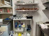 a small kitchen with a lot of clutter on the shelves