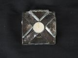 a glass candle holder with a candle in it on a black background