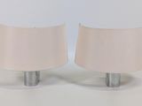 une paire de lampes blanches posées sur une surface blanche, avec un fond blanc