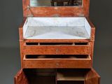 a small wooden dresser with a mirror on top of it