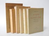 several books are stacked on top of each other on a white surface