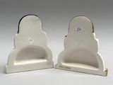 two white ceramic bookends with a black and white design