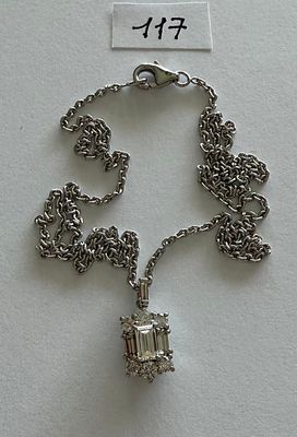 a silver chain with a pendant on it on a table