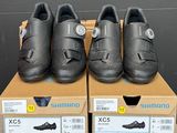 trois paires de chaussures Shimano posées sur une boîte
