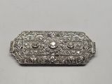 une broche en argent ornée d'un diamant au centre