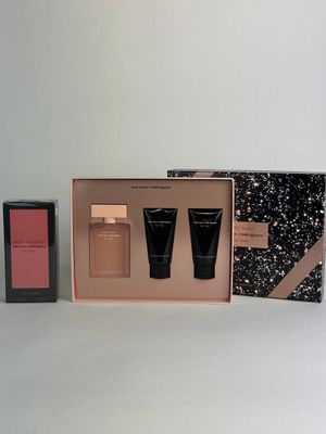 two bottles of perfume in a pink box with a black and white box