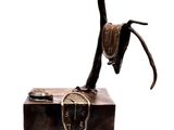 statue d'un cheval avec une selle sur le dos, posée sur une caisse en bois