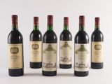 six bottles of wine are lined up in a row on a white surface