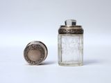 a small glass jar with a silver lid next to a small glass jar
