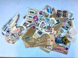 a pile of stamps on a table with a roll of paper