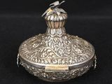 a silver box with a bird sitting on top of it