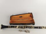 a black and gold clarinet with a case on the table
