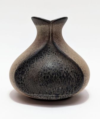 a black and white vase sitting on a white surface