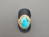 un gros plan d'une bague sertie d'une pierre de turquoise