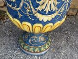 a blue and yellow vase with a face on it