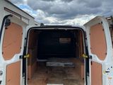 the back of a white van with its doors open in a parking lot