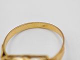 a close up of a gold ring on a white surface