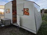 a small white trailer with a kitchen inside of it
