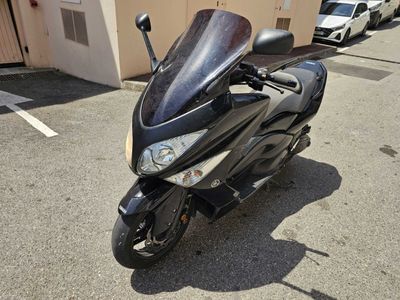 une moto noire garée sur un parking à côté d'un immeuble