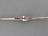 a close up of a white and red hair clip on a gray surface