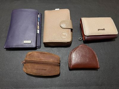 four different types of leather wallets sitting on a table