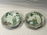 two bowls with asian designs on them on a table