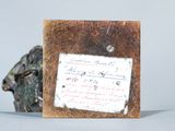 a small piece of paper on the table next to a statue of a bull