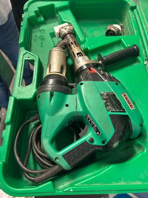 a green box with a drill and other tools in it