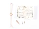 a watch and a pair of scissors on a white surface
