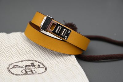 un gros plan sur un bracelet en cuir jaune muni d'une boucle en argent