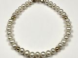 gros plan d'un collier de perles blanches sur une surface blanche