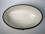 a white bowl with a black rim sitting on a table