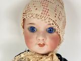 a close up of a doll with a hat on
