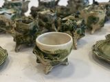 many pieces of pottery sitting on a white table