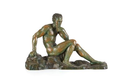 statue en bronze représentant un homme assis sur un rocher, les jambes croisées