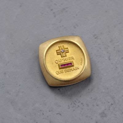 bague en or jaune ornée d'une croix et d'une pierre rose au centre