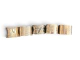 several pieces of gold and silver bracelets on a white surface