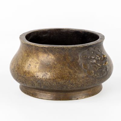 un petit pot en métal orné d'un motif