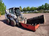 a picture of a skid steer loader parked in a dirt lot