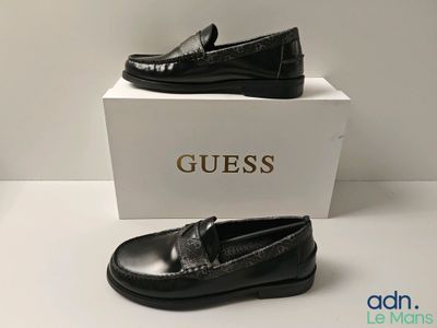 two pairs of black shoes sitting on top of a white box