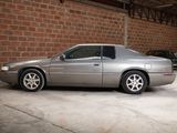 a silver car parked in a garage next to a brick wall